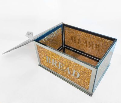 Brödbox i glas med gulddetaljer och texten BREAD på, och ett lock av spegelglas 