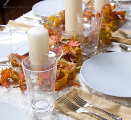 Bild på ett exempel på dukning under hösten. Här har man lagt löv på bordet som dekoration för dukningen